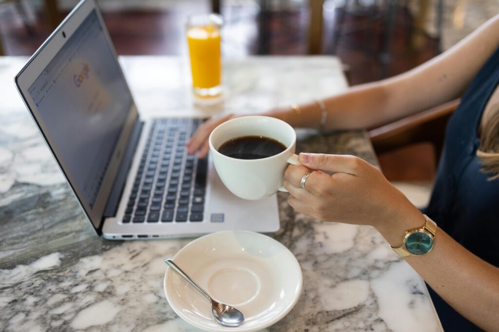 A woman business owner is having a cup of coffee while browsing.