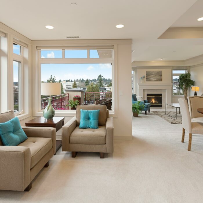 A real estate image of a room with beige sofas and chairs.