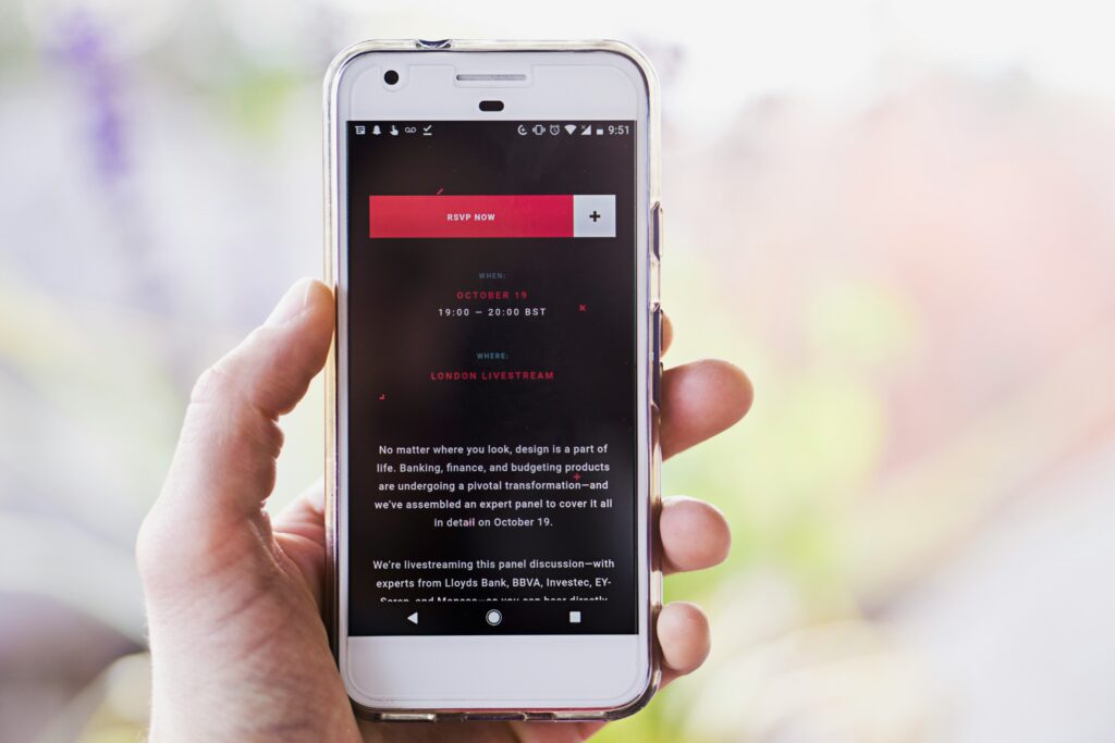 A person holding a phone displaying newsletter