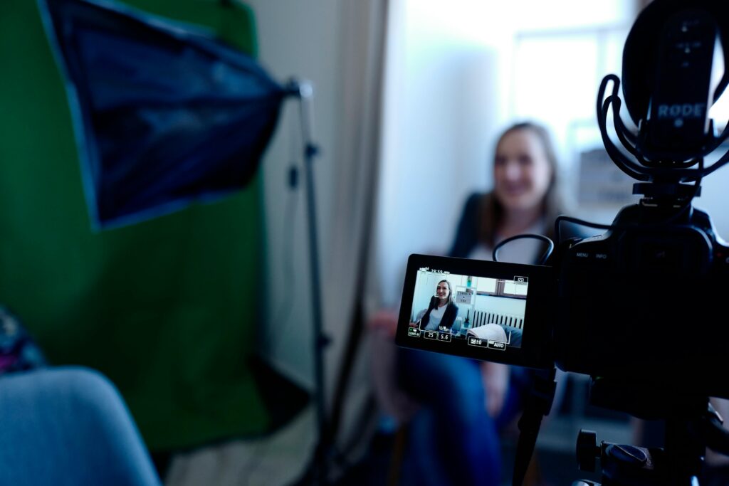 A camera recording a woman sitting in a chair